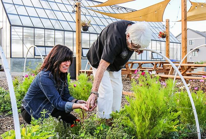 Two women outside of the greenhouse